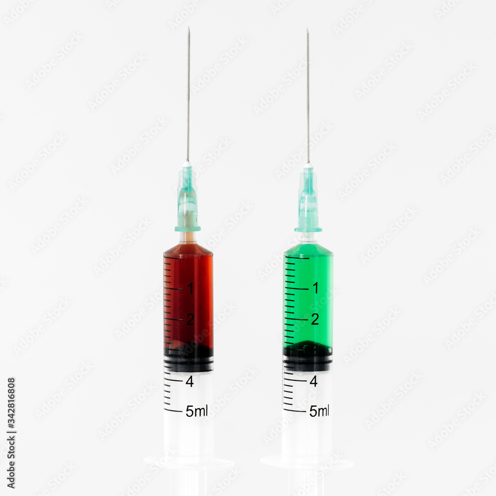 Two syringes with red and green serum Two syringes with red and green serum