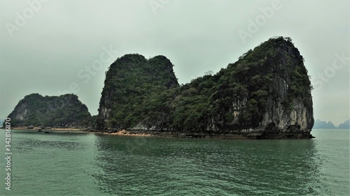 Rainy and foggy day in Halong Bay. Forest covered islands rise straight from the water.