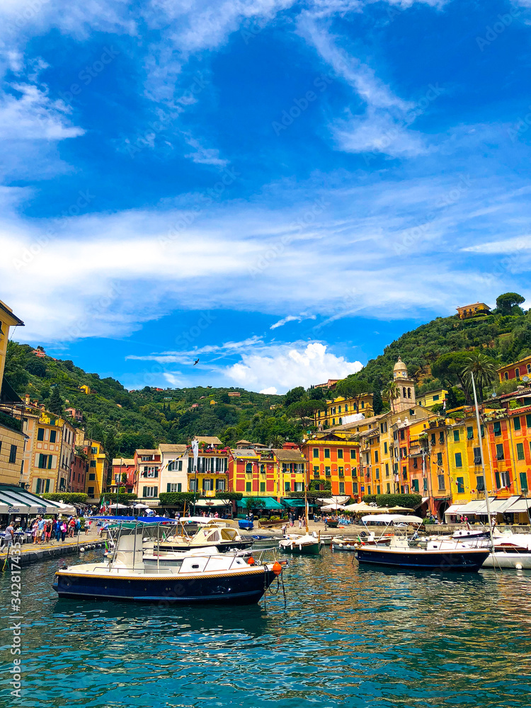 Stunning view of boats and yachts moored in the harbor of Portofino, one of the world's most beautiful seaside towns on the Italian Riviera. Mediterranean landscape of yacht-filled harbor. ITALY