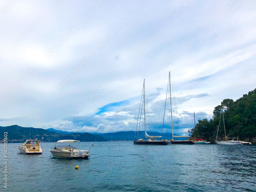 Stunning view of boats and yachts moored in the harbor of Portofino, one of the world's most beautiful seaside towns on the Italian Riviera. Mediterranean landscape of yacht-filled harbor. ITALY