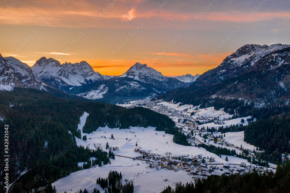 Fototapeta premium snowy city in italian alps at sunset