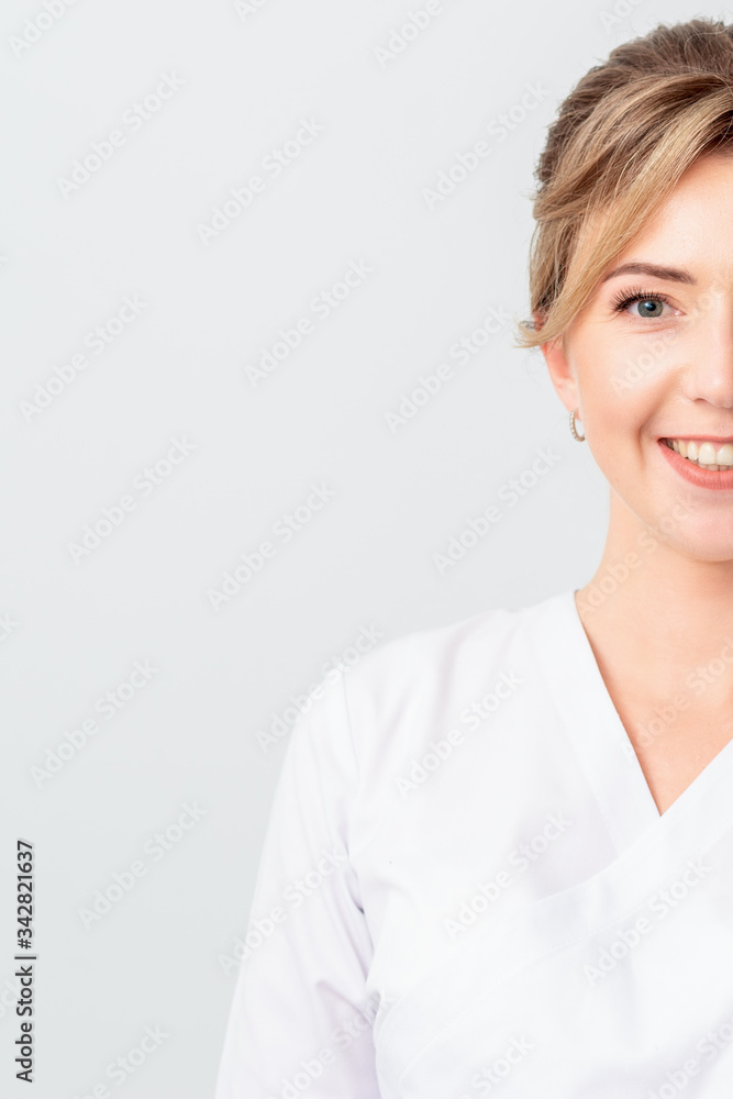 Portrait of half face beautiful doctor or intern or cosmetologist in white robe stands smiling at the camera, isolated on white background. Portrait of half face beautiful doctor or intern or cosmetologist in white robe stands smiling at the camera, isolated on white background.