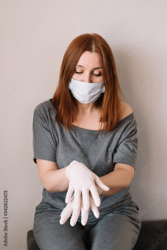 Woman wearing face mask and latex gloves staying at home. COVID-19 concept Woman wearing face mask and latex gloves staying at home. COVID-19 concept