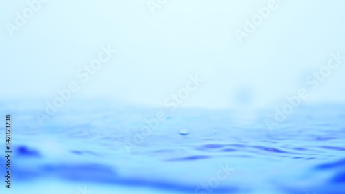 Soft blur focus of Abstract water splash surface filling the frame with the water drop and waving liquid with an air bubble on a white background and copy space.