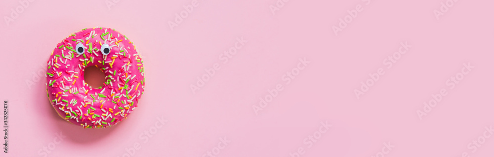 Pink donut with eyes on a pink background Pink donut with eyes on a pink background