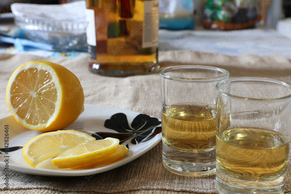 Glasses with whisky and lemon slices on the table. Selective focus. Glasses with whisky and lemon slices on the table. Selective focus.