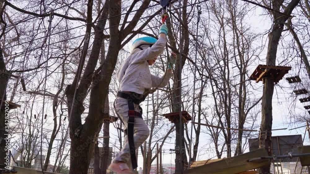 a child girl fears climb in rope Park in spring a child girl fears climb in rope Park in spring