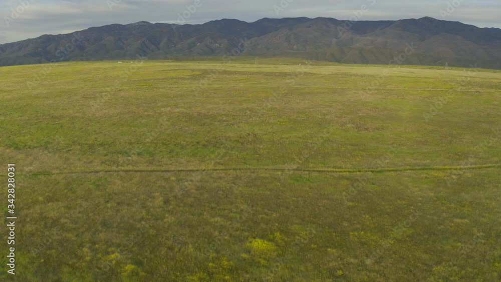 Flying over a green prairie high above the Aqua Fria National Monument in Arizona with interstate traffic and mountains in the distance. Flying over a green prairie high above the Aqua Fria National Monument in Arizona with interstate traffic and mountains in the distance.
