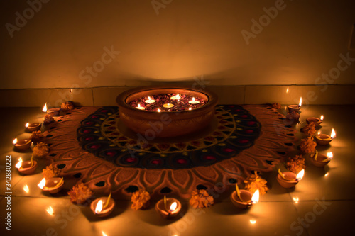 Beautiful clay lamp lit around a rangoli during Festival of Lights, Diwali in India photo