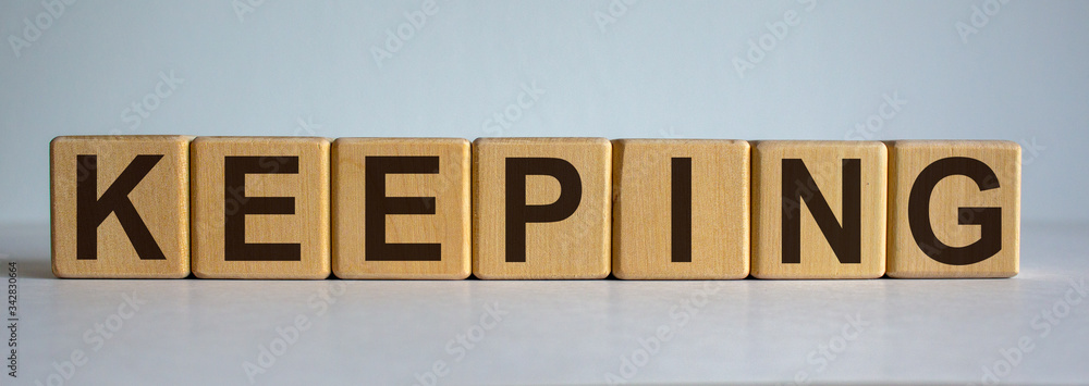 Fototapeta premium Concept word 'keeping' on cubes on a beautiful white background.