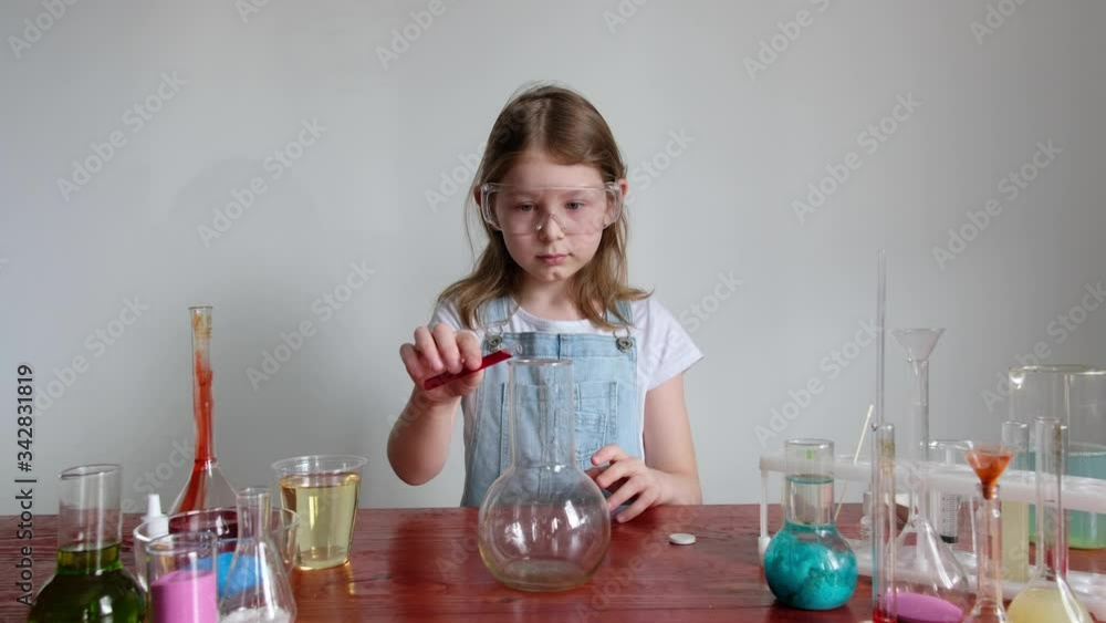 A girl in home clothes conducts chemical experiments at home. home lab. A girl in home clothes conducts chemical experiments at home. home lab.