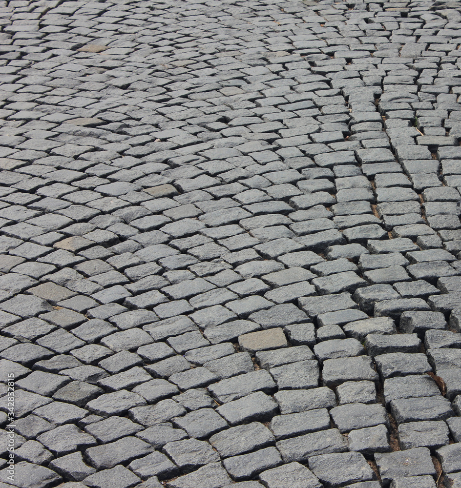 Brick stone street pavement background. Empty gray brick stone pavement perspective, abstract cobblestone road pattern