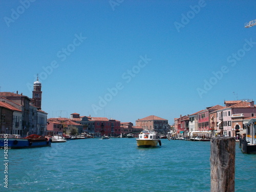 A small boat in a body of water with a city in the backgroundundefined