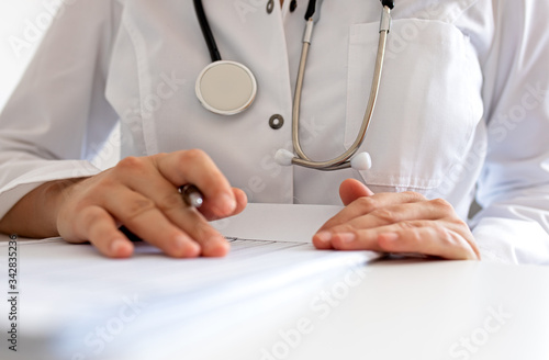 Doctor's hand making notes while sitting isolated on white
