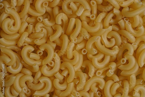 yellow natural background of dried small pasta in a heap