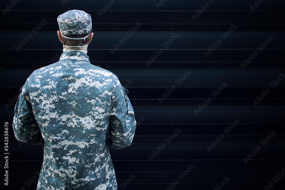 Portrait of soldier in military uniform with protective gloves and mask facing his back to the camera. Portrait of soldier in military uniform with protective gloves and mask facing his back to the camera.