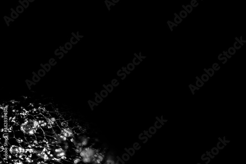 Background and backsplash of wet net with moist crystal water drops stuck between strings - abstract structure, technology, design black and white © Nina