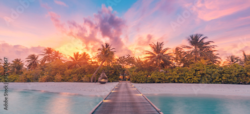 Landscape of paradise tropical island beach, sunrise sunset view. Exotic scenery, palm trees, soft sand and calm sea. Summer beach landscape, vacation or tropical travel sunset colors clouds horizon 