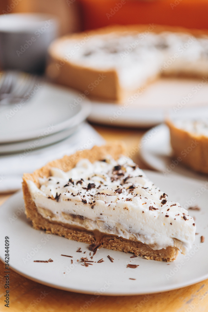 appetizing slice of sand-based dessert with white cream cheese and banana stuffing sprinkled with grated chocolate appetizing slice of sand-based dessert with white cream cheese and banana stuffing sprinkled with grated chocolate
