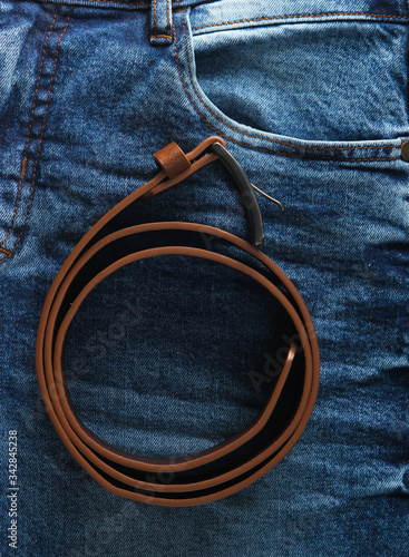 Brown leather belt with jeans close-up