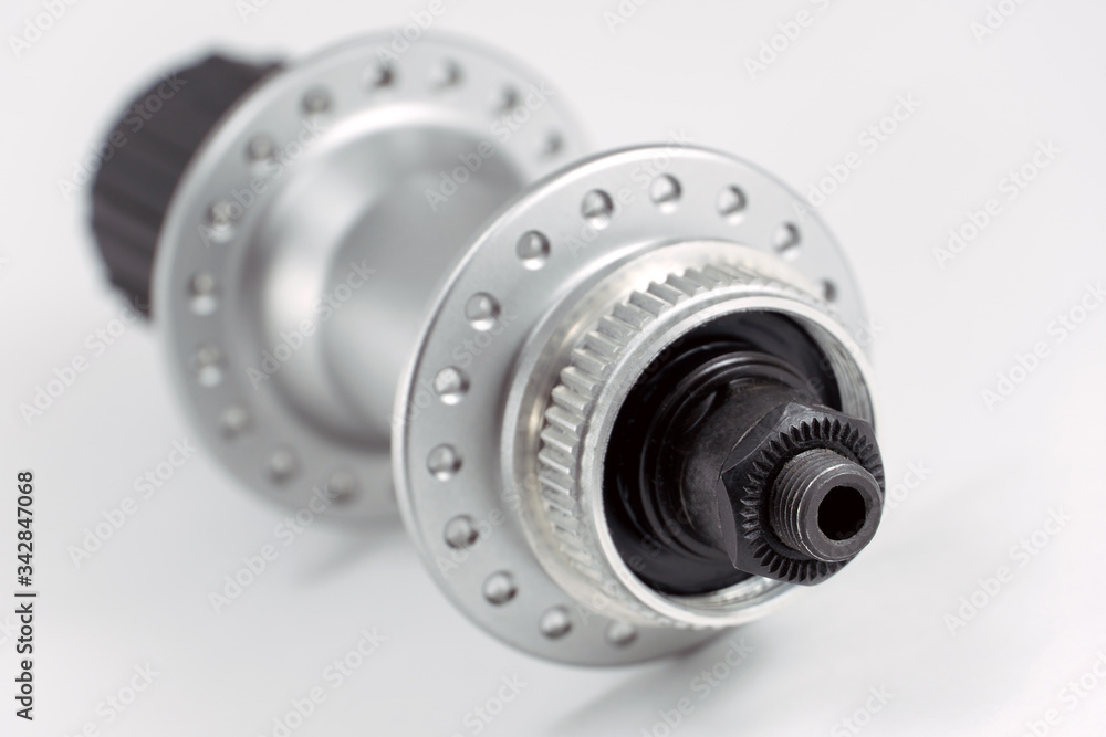 Bicycle repair. Mountain bike workshop. Rear hub under the disc brake on a white background. The body is silver. Spare parts for a bicycle of a famous manufacturer and brand.
