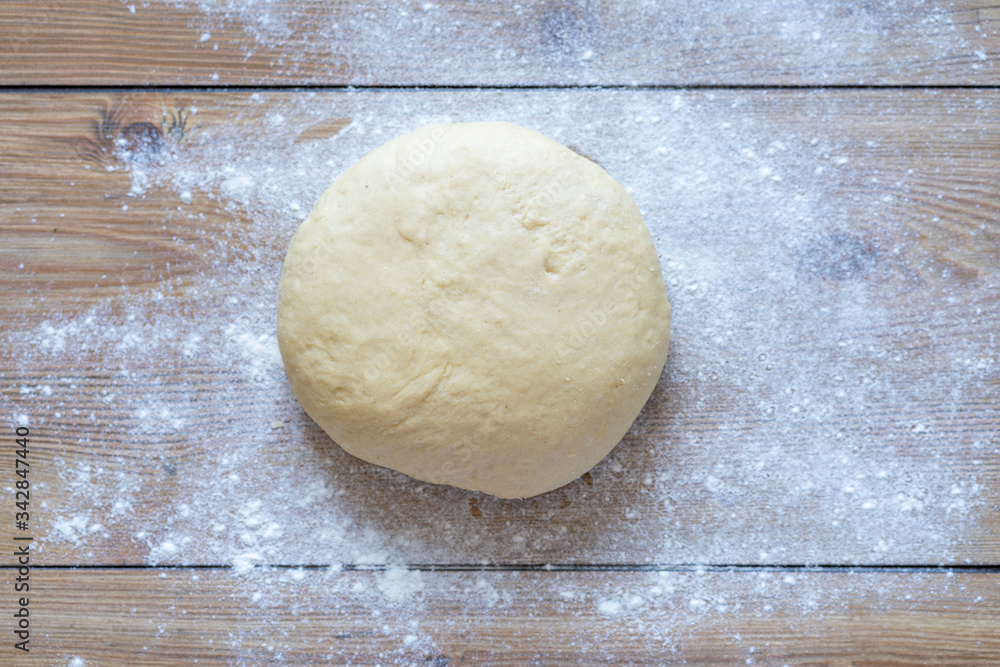 bread dough ready for kneading. preparing the dough on a wooden table. Knead dough in homemade kitchen bread dough ready for kneading. preparing the dough on a wooden table. Knead dough in homemade kitchen