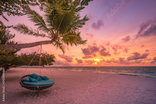 Tropical beach sunset as summer landscape with luxury resort beach swing or hammock and white sand and calm sea for sunset beach landscape. Tranquil beach scenery vacation and summer holiday concept. 