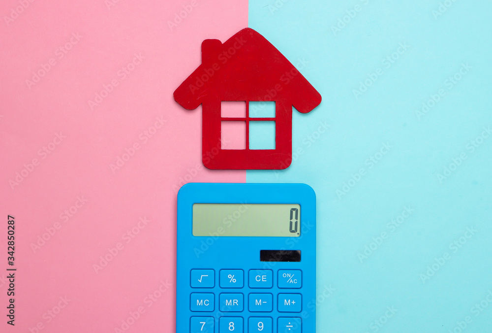 Calculation of the cost of rental housing. Red house figurine, calculator on pink blue pastel background. Top view Calculation of the cost of rental housing. Red house figurine, calculator on pink blue pastel background. Top view