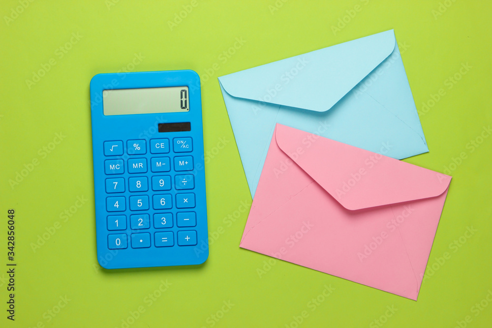 Calculator with envelopes on green background. Top view Calculator with envelopes on green background. Top view
