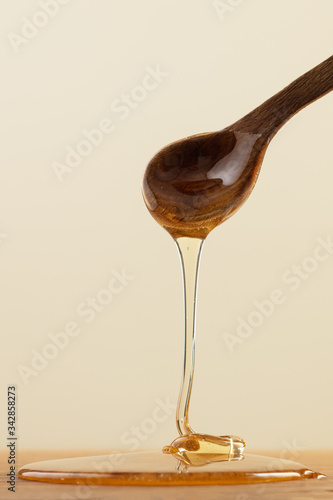 Wallpaper Mural Tasty honey in spoon on yellow background. Thick honey dipping from the wooden honey spoon. Torontodigital.ca