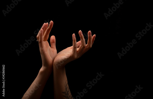 Female hands on a black background.