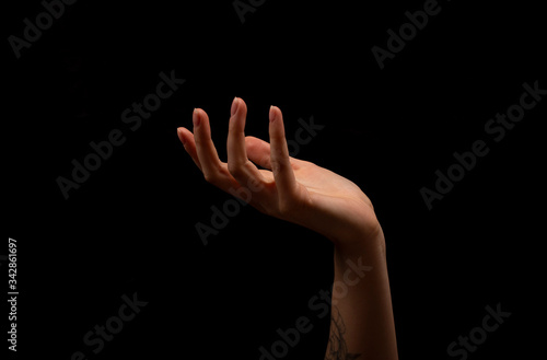 Woman hand on black background. Holding or offering. Outstretched female hand, girl keeping empty palm on black isolated background