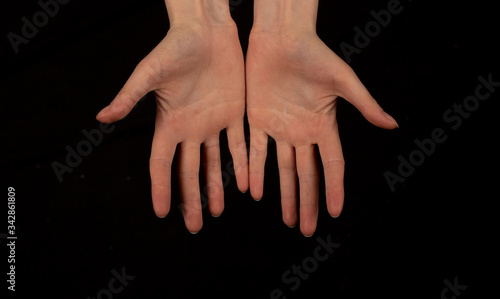 Female hands on a black background.