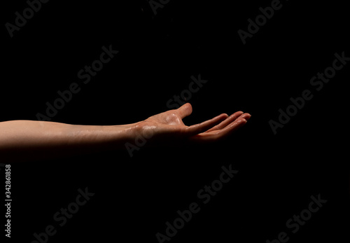 Woman hand on black background. Holding or offering. Outstretched female hand, girl keeping empty palm on black isolated background