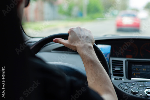 Wallpaper Mural Man driving. The driver holds the steering wheel with his hand. Torontodigital.ca