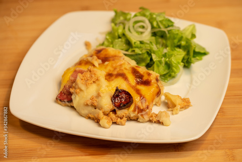 Mashed potatoes baked with meat with lettuce salad on side