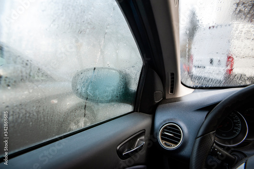 Steamy car windows on a autumn rainy/foggy day. Concept of safety driving problem