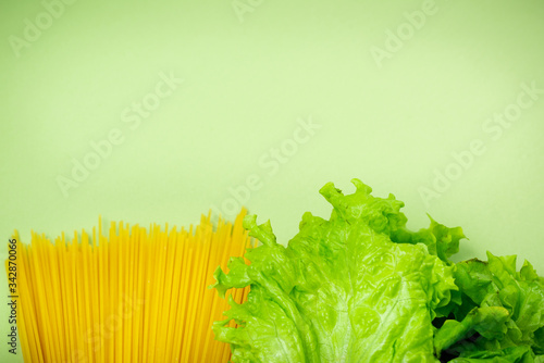 Essential fresh products lie on a green background. Greens, spaghetti, food. Food delivery covid-19 epidemic, Donation. top view. Copy space. photo