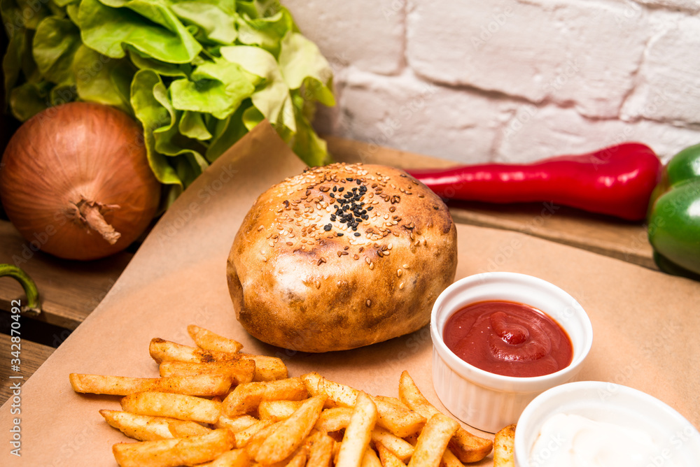 Burger and different vegetables on the wooden table. Flat lay Burger and different vegetables on the wooden table. Flat lay