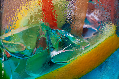 Abstract background. Pieces of ice in drink with lemon. Macro photo. Neon blue yellow backlight,Ice Tea, Whiskey, Ice Cube, Ice, Cocktail