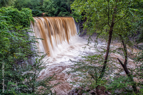Dramatic Vickery Creek Falls at Old Mill Park during flood.