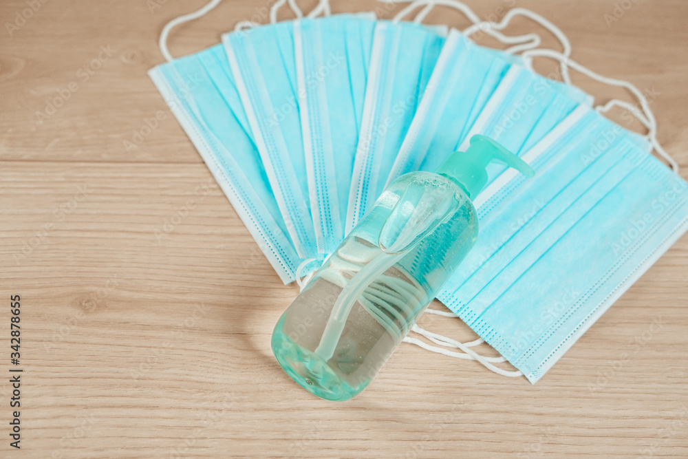 Prevention against the spread of the corona virus - COVID-19. Disinfectant gel and face mask for protection on the wooden table. Prevention against the spread of the corona virus - COVID-19. Disinfectant gel and face mask for protection on the wooden table.