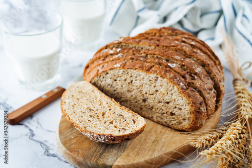 Wholegrain rye bread with glasses of milk photo