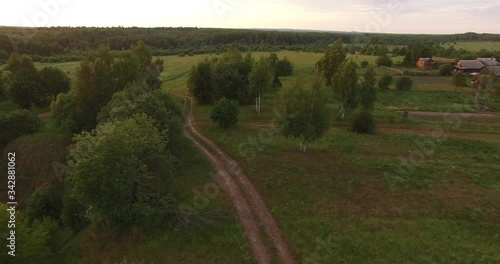 4K aerial bright autumn sunset high quality video footage of lush bright red and brown countryside forest and fields in rural village outskirts in Yaroslavl region of Russia photo