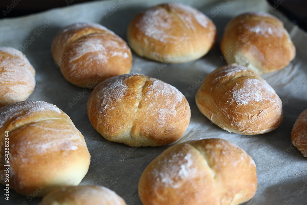 Baking rolls - hot crisp rolls on a baking tray removed from the oven