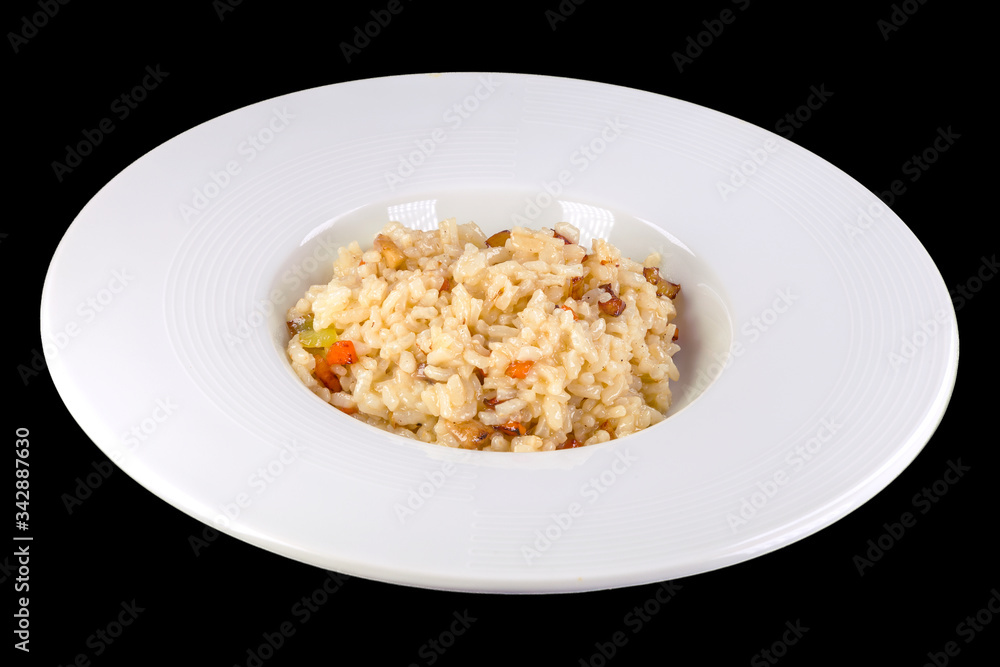 Tasty risotto with vegetables in a white plate, isolated on black background