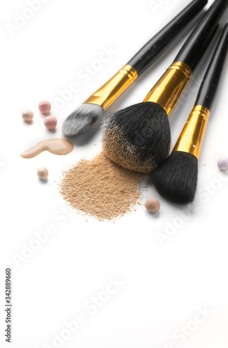 Cosmetic liquid foundation or cream, loose face powder, various brushes for apply makeup. Make up concealer smear and powder isolated on a white background. Products for Perfect face skin makeup. 