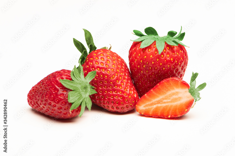 fresh strawberries and a sliced strawberry close up on a white background fresh strawberries and a sliced strawberry close up on a white background