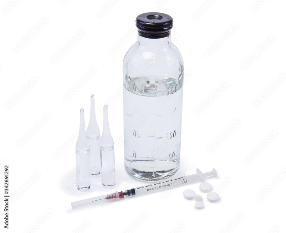 glass ampoules with medicine, saline bottle, syringe and pills are reflected in a mirror surface isolated on white background glass ampoules with medicine, saline bottle, syringe and pills are reflected in a mirror surface isolated on white background