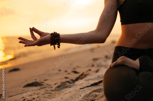 Photography Meditating girl on the seashore during sunset